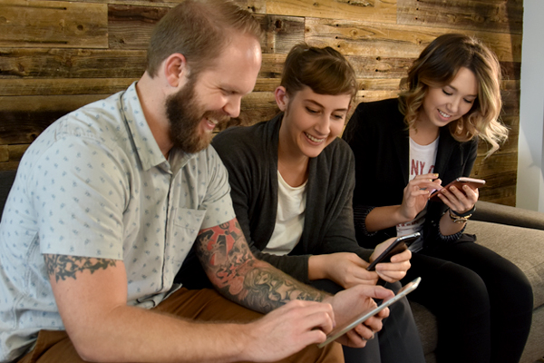 Orange Label team members checking their phones